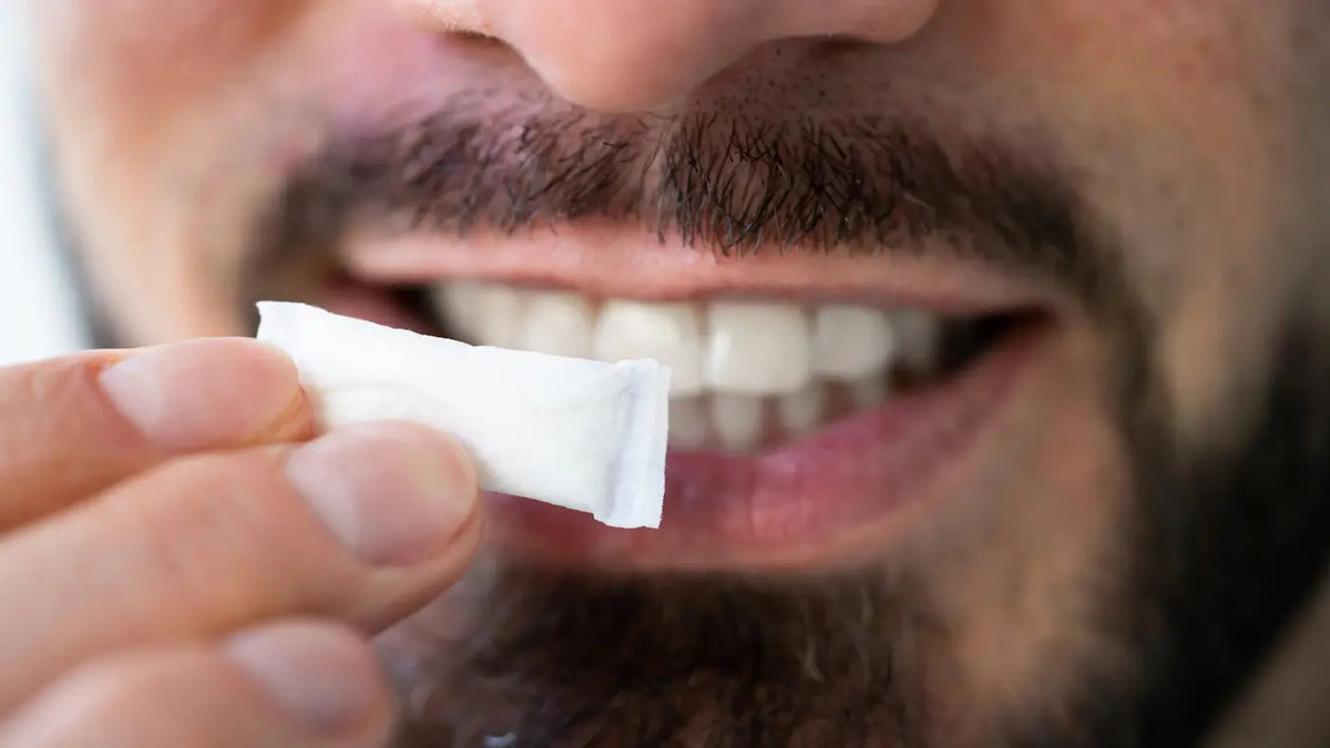 Person holding a nicotine pouch near their mouth showing how to use ZYN nicotine pouches